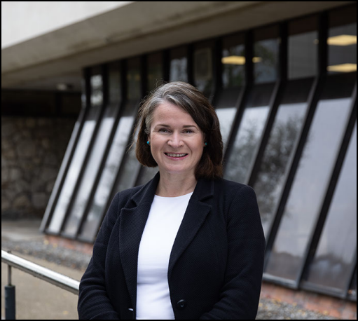 A woman standing, she is a professor.