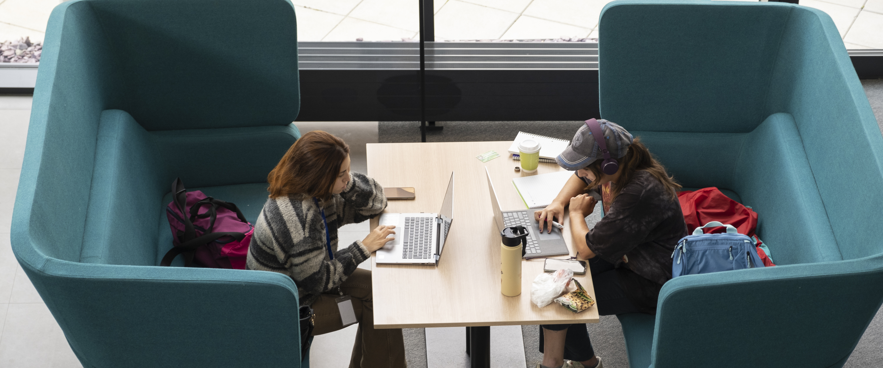 Students using laptops at a table on campus