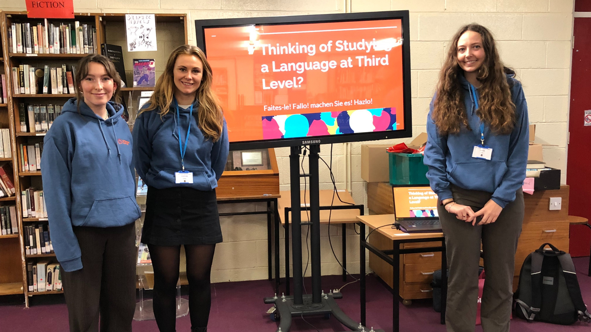 Three students in front of a presentation