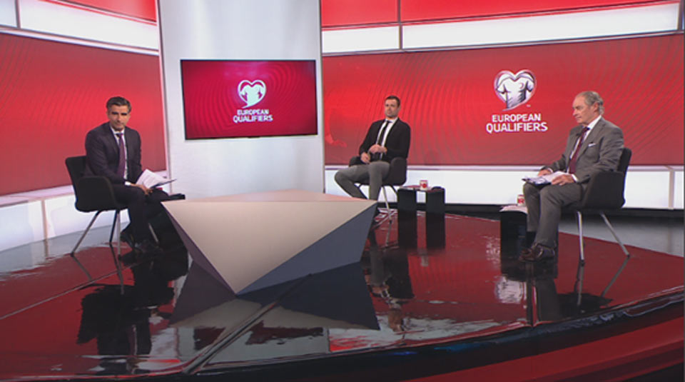 Three tv sports pundits on a red background