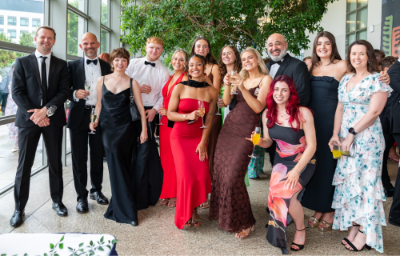Students and staff in the conservatory of O Reilly Hall in formal attire for group shot