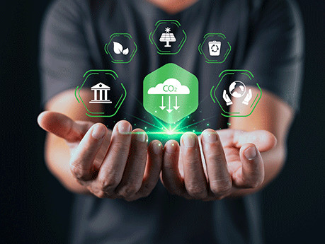 A person holds out their hands beneath glowing eco icons and a green CO2 cloud symbol, representing environmental sustainability, carbon reduction, and clean energy initiatives
