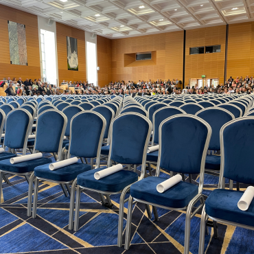 Empty chairs with graduation scrolls on each