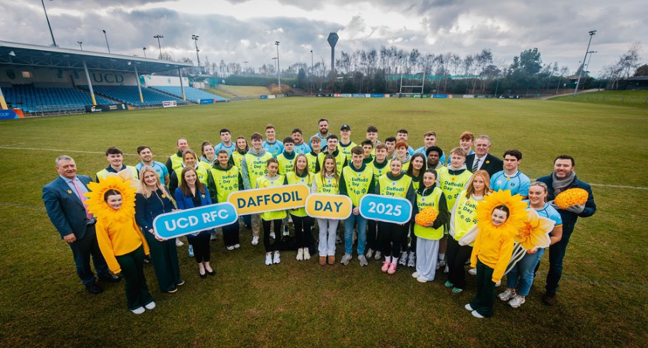 Group of students and rugby players on a pitch at UCD