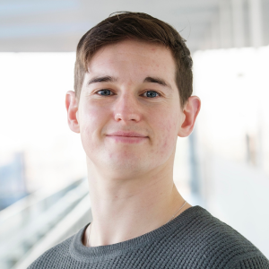 Man with dark hair smiling to camera