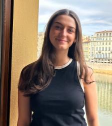 Sarah standing on a balcony with a river in the background