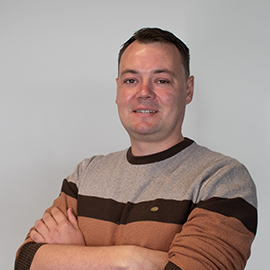 A man smiling to the camera.